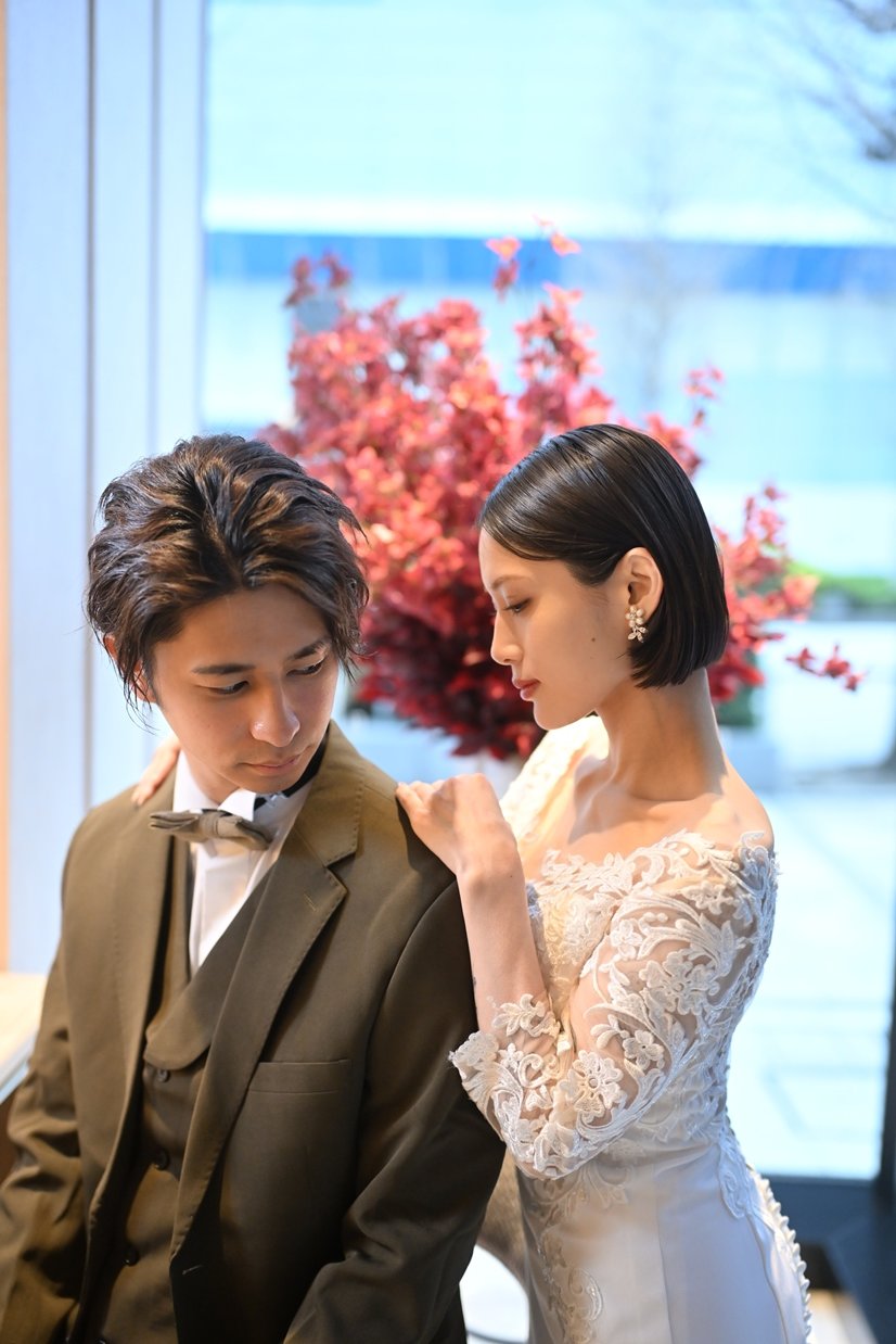 A couple framed by striking red floral art