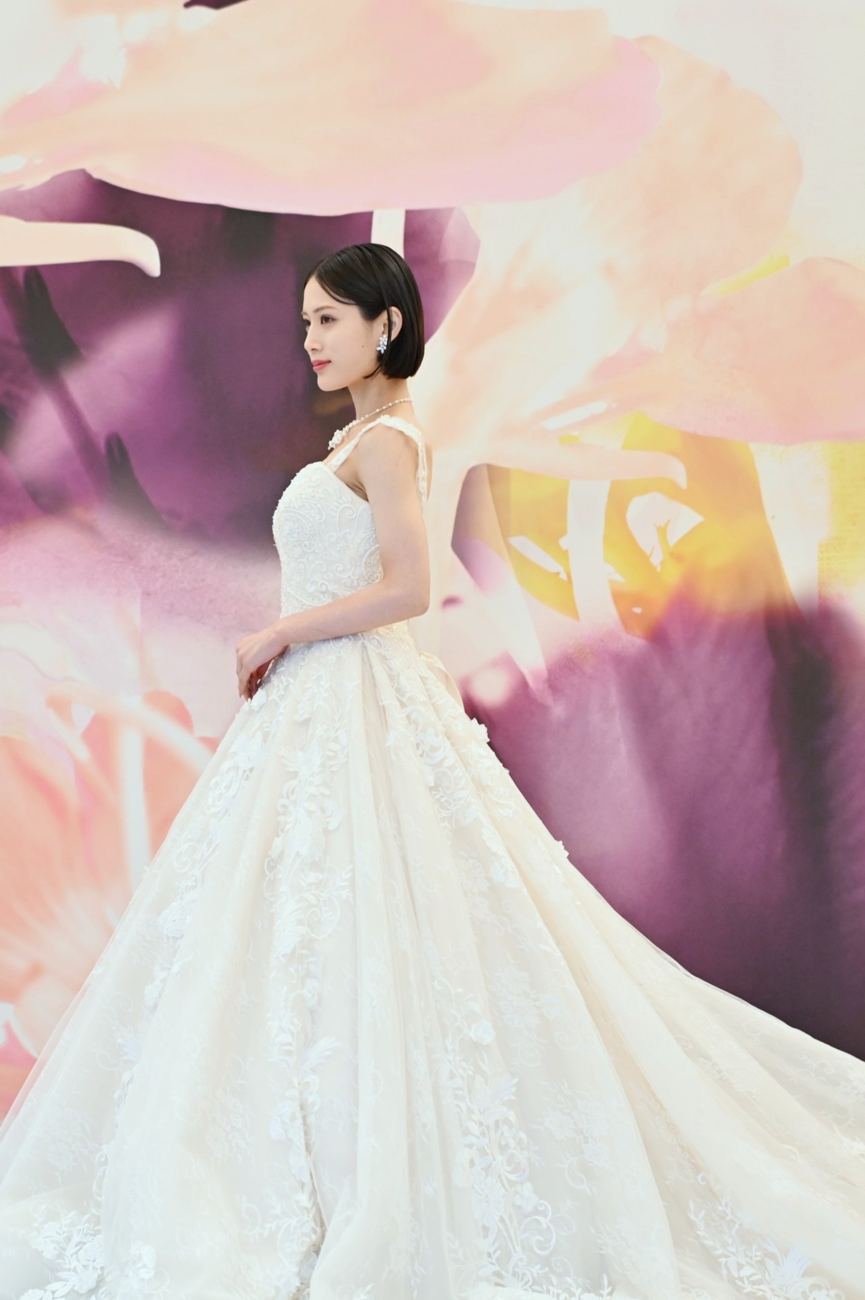 A stylish wedding photo with a floral art wall