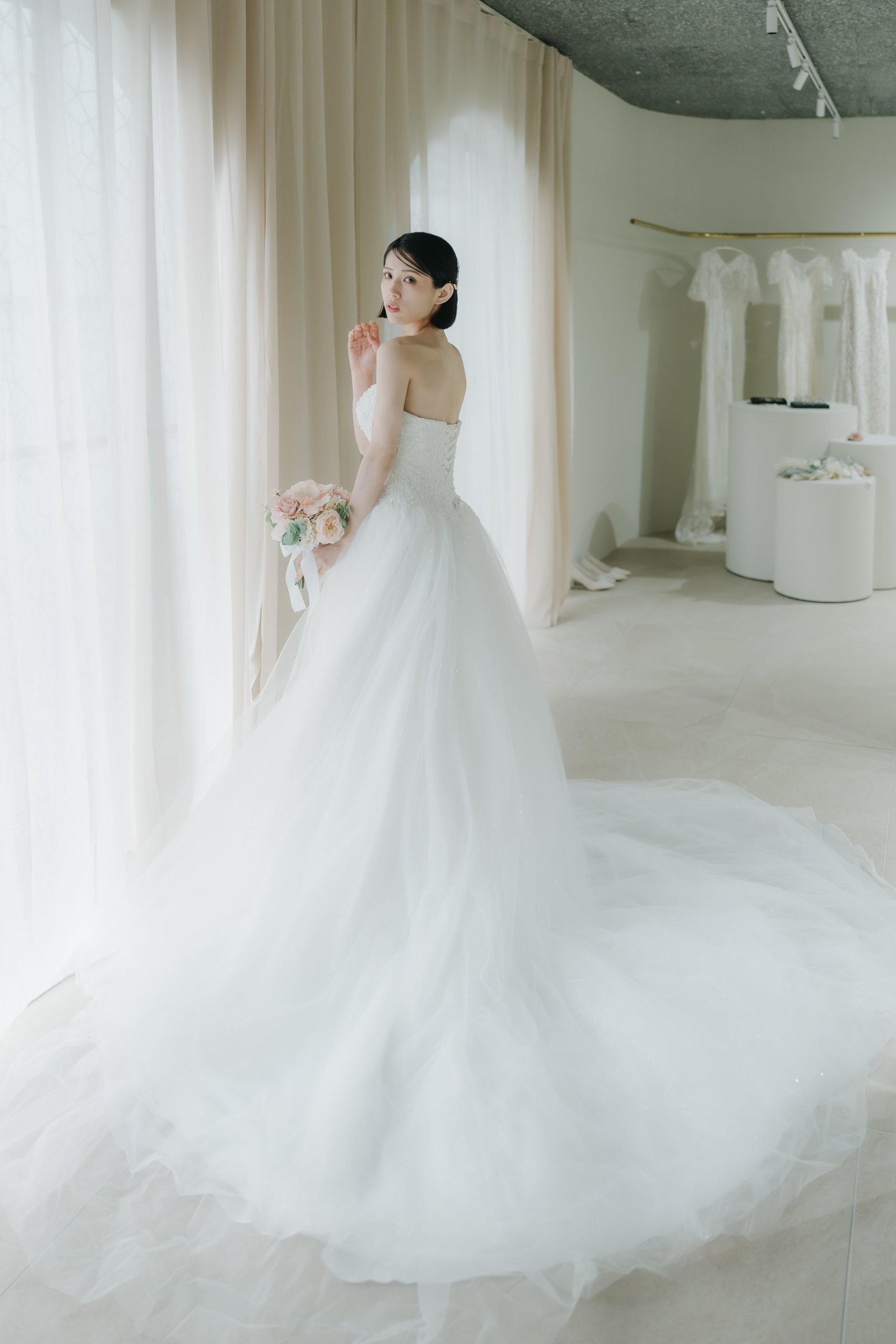 Bride in a sheer lace organza wedding dress with sunlight filtering through the fabric in Tokyo
