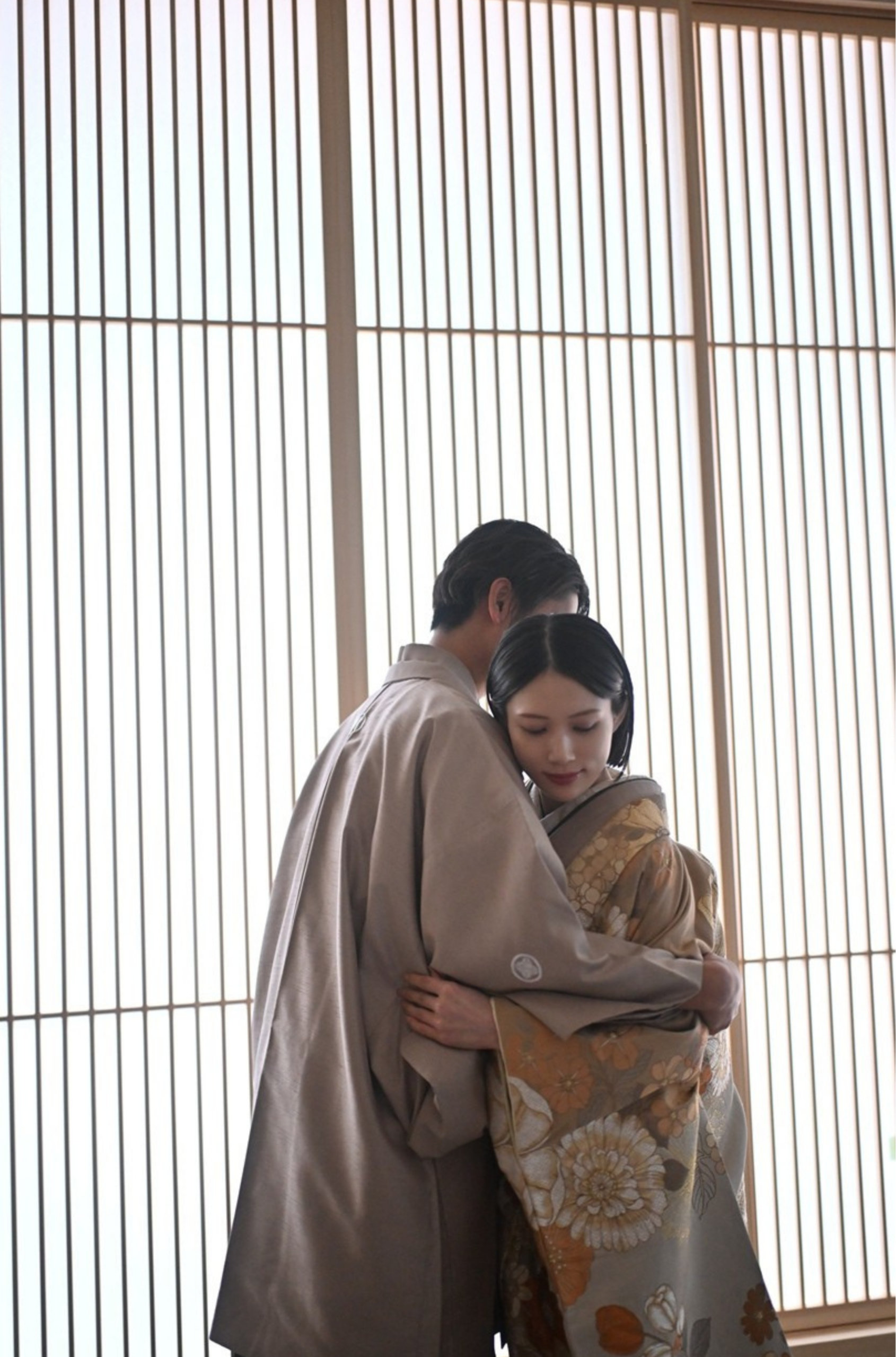 Couple in kimono and wedding dress sharing an intimate moment inside the Wa-Modern studio