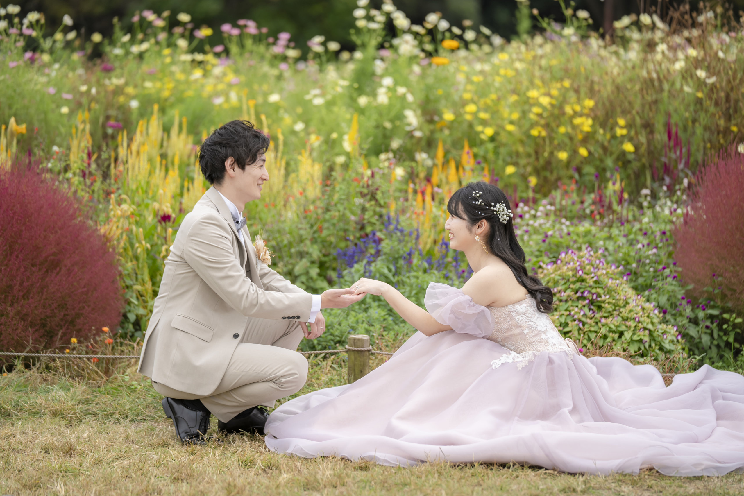Dress selection at Showa Memorial Park — white wedding dress creates contrast against the flower fields, while color dresses harmonize with or complement the seasonal blooms