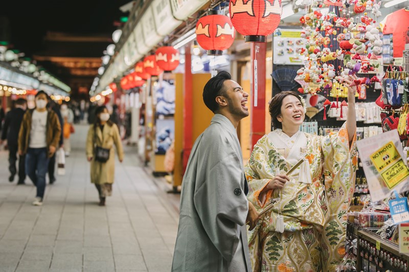 Asakusa Nakamise shopping street wedding photography — kimono-clad couple walking the lantern-lined stone path toward Senso-ji temple