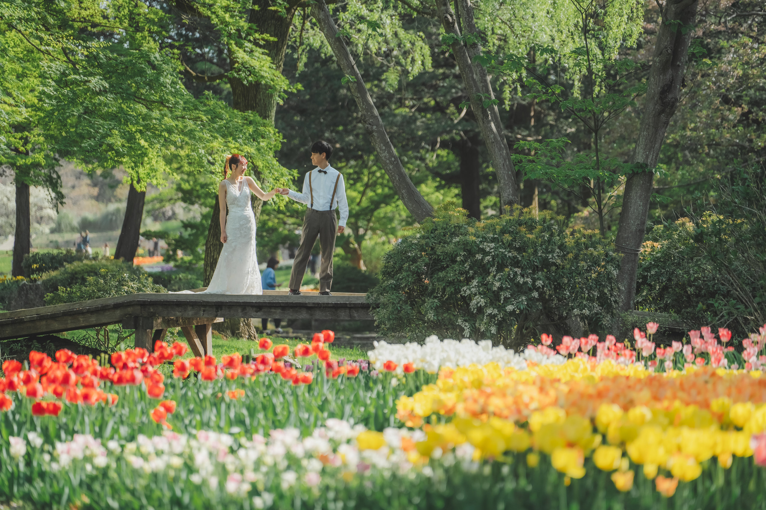 Showa Memorial Park wedding photography — bride in wedding dress standing in the vast flower field, surrounded by seasonal blooms extending to the horizon