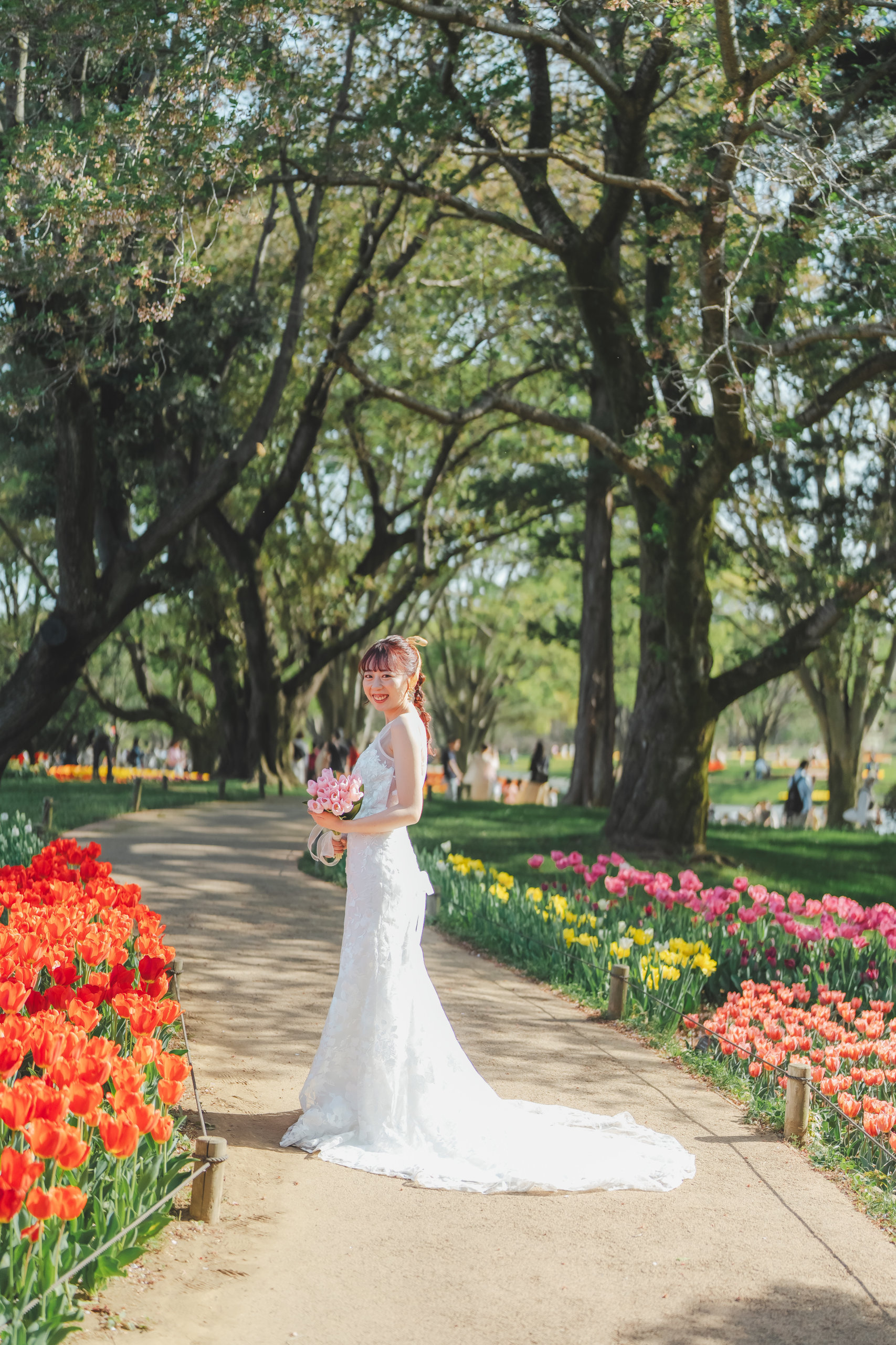 Showa Memorial Park Hana-no-oka wedding photography — bride in white wedding dress surrounded by the seasonal flower field extending to the horizon