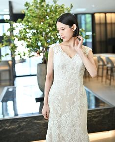 A-Line style wedding dress (AC04): An elegant gown from White One, a sister brand of the Barcelona-based PRONOVIAS group. The beige lining beautifully highlights the delicate white embroidery, creating a refined and subtly alluring look. The deep, graceful V-cut back is adorned with a row of covered buttons, adding a sophisticated and delicate touch.