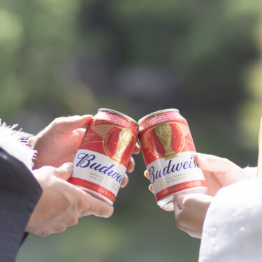 Close-up of a bride and groom in wedding kimono clinking canned drinks for a toast, a casual and modern touch in a traditional Japanese garden