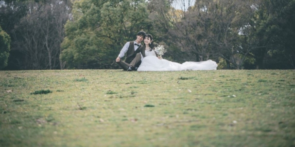 Sitting together on the open lawn at Daisen Park, a quiet, relaxed moment in Sakai's most scenic wedding photography spot.
