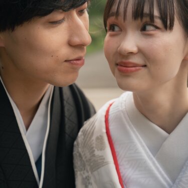 Close-up of a couple in traditional Japanese wedding kimono gazing into each other's eyes with gentle smiles