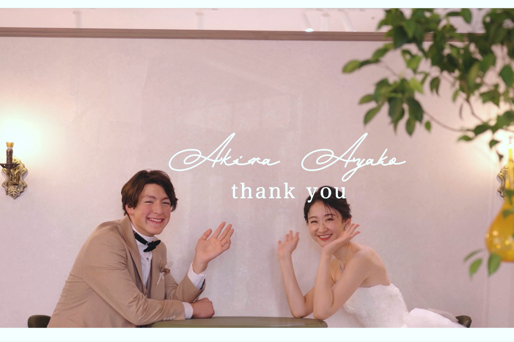 Video still reading 'Akira Ayako thank you', couple waving cheerfully while seated at a table.