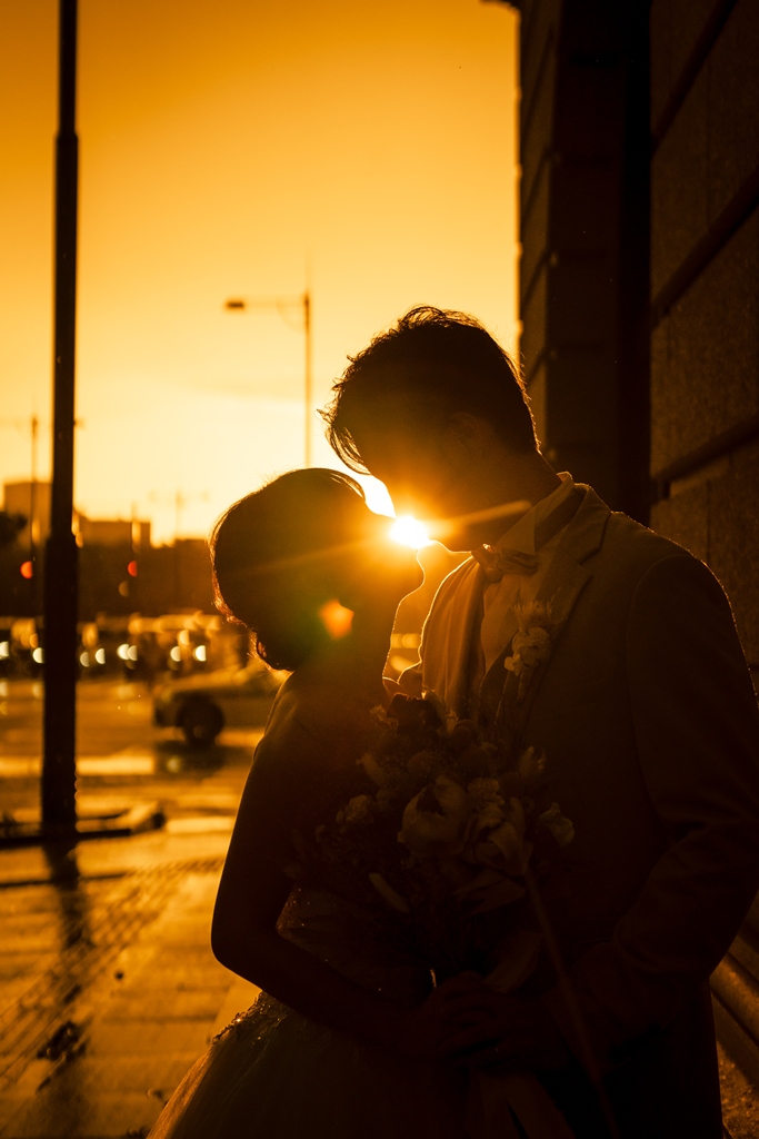 A smiling couple gazing at each other, surrounded by soft light