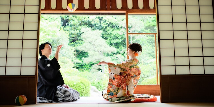 Playing catch with a colorful ball in a sunlit tatami room opening onto the garden at Touzansou, a playful pose from their Japan wedding photography session.