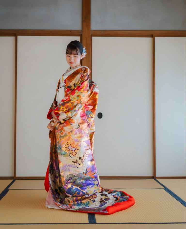 Bride in a gold and purple uchikake with auspicious motifs, her long train trailing across tatami in a shoji-lined Japanese room at our Yokohama studio — kimono pre-wedding photoshoot in Japan (Shitsuru / YB15)