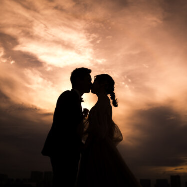Silhouette of the bride and groom kissing under a dramatic sunset sky, a cinematic pre-wedding photoshoot in Tokyo