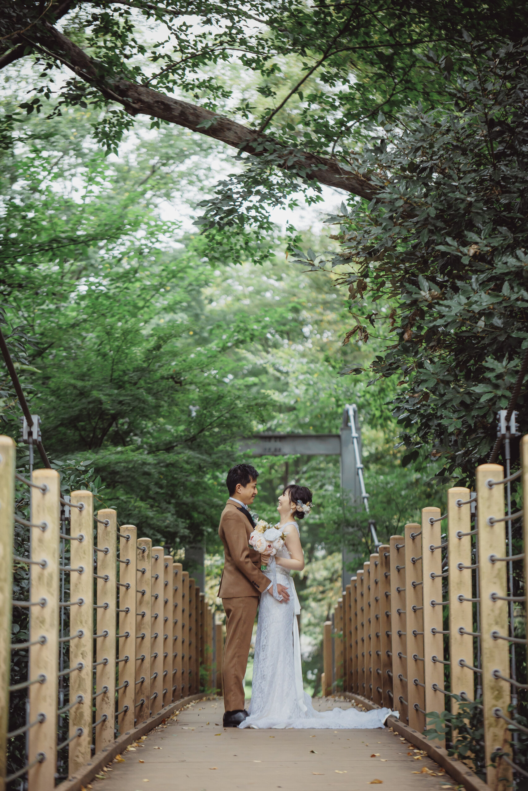 Walking across the suspension bridge at Kinuta Park in a wedding dress — natural movement creates effortless, candid-feeling photos
