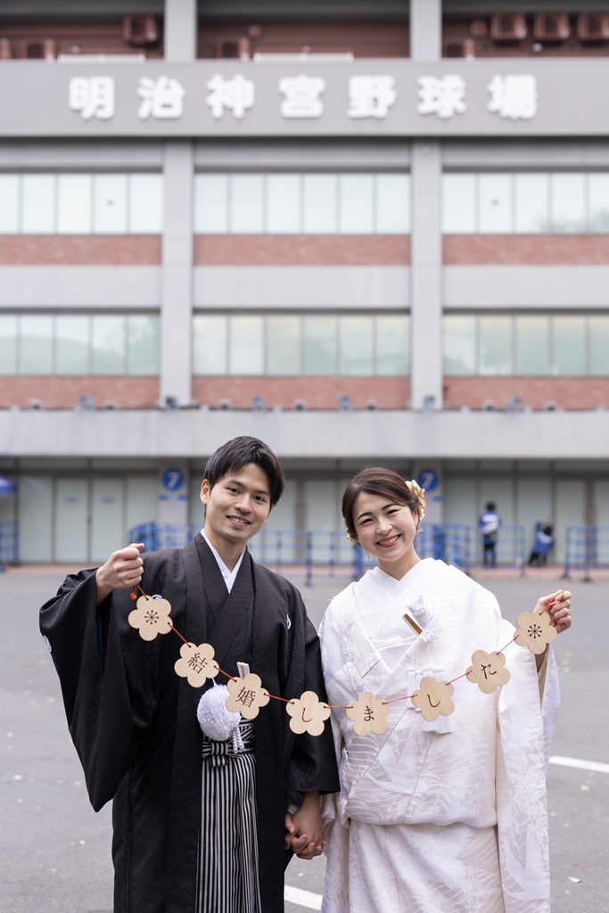 Kimono couple holding a just married garland in front of Jingu Stadium near the Jingu Gaien Ginkgo Avenue