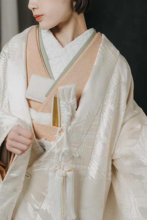 Close-up of a shiromuku collar with a salmon-pink under-kimono, hakoseko and tasseled kaiken dagger, accessories worth capturing in a pre-wedding photoshoot in Japan (DR101).