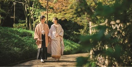 A couple in kimono walks hand in hand through an autumn garden, representing Wedding Avenue Yokohama.