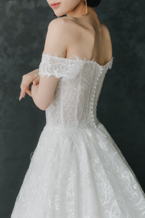 Back view of the off-shoulder lace wedding dress showing covered buttons down the back, delicate details that stand out in Japan wedding photography